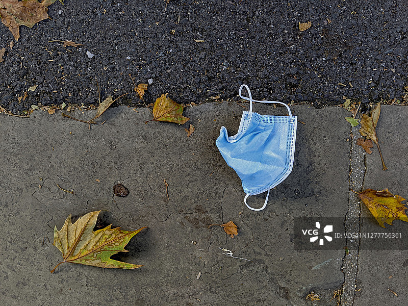 留在人行道上的废弃医用口罩图片素材