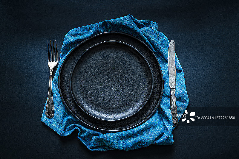 深色餐桌上的黑色餐具摆放（俯视）图片素材
