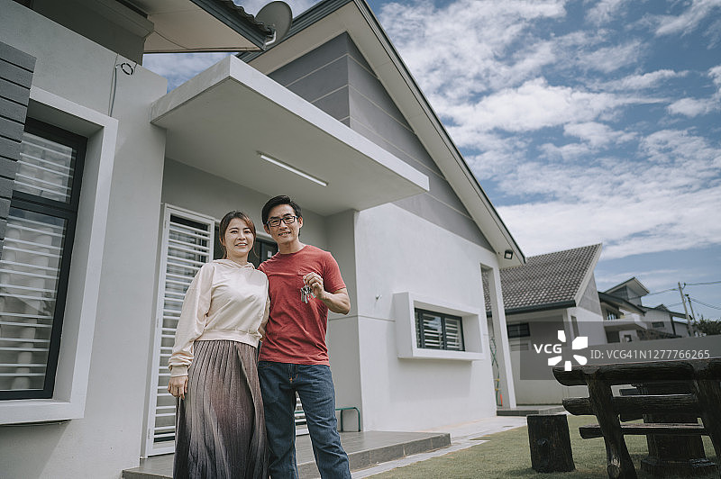亚洲华人年轻夫妇高兴地收到他们新房的钥匙图片素材
