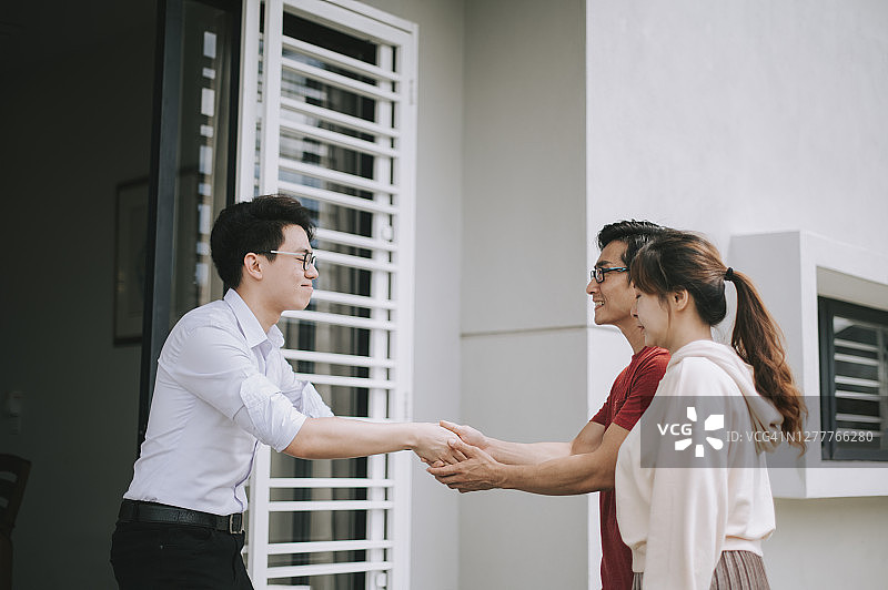 一对华人夫妇从房产中介手中接过新房钥匙图片素材