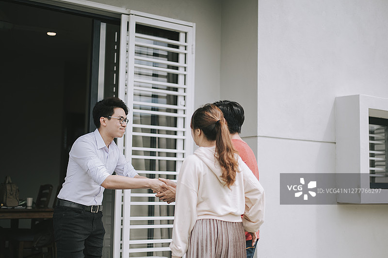 一对华人夫妇从房产中介手中接过新房钥匙图片素材