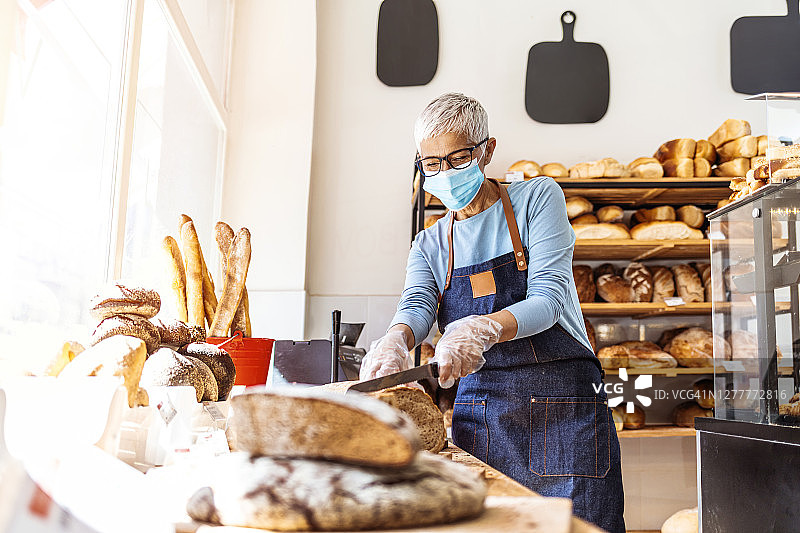 戴口罩在食品店工作的店主图片素材