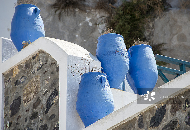庭院中的三个深蓝色希腊瓮，位于希腊圣托里尼岛的费拉图片素材