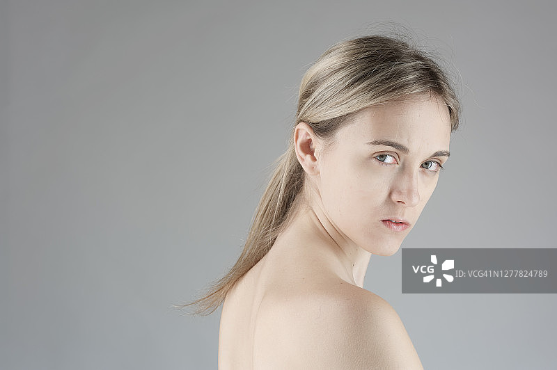 的年轻女子在灰色的背景图片素材