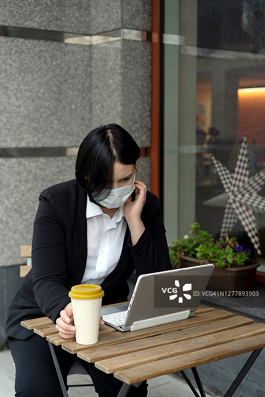 疫情期间戴防护口罩用手机交谈的年轻漂亮女子肖像图片素材