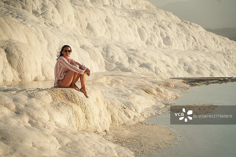 年轻漂亮的女子在土耳其棉花堡度假，享受阳光图片素材
