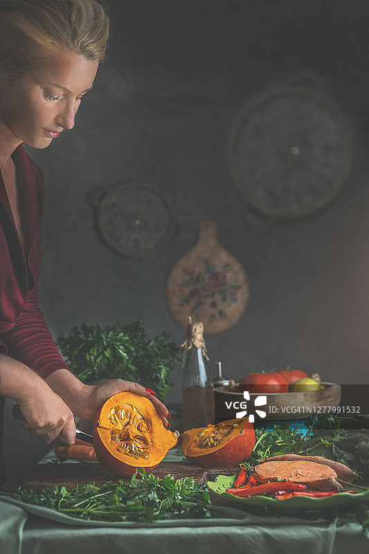 漂亮的女人在舒适的乡村厨房里准备南瓜和红薯图片素材