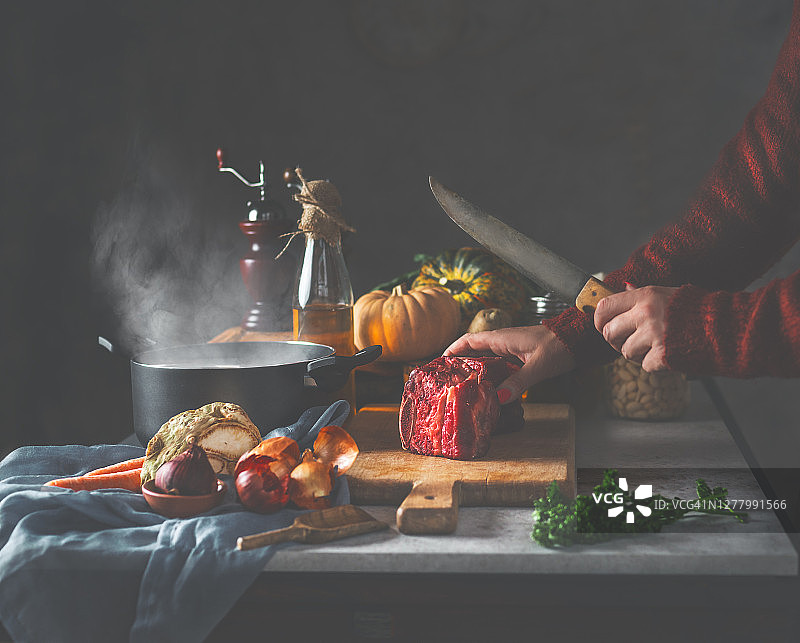 女人烹饪美味的肉汤，用刀准备牛腩肉图片素材