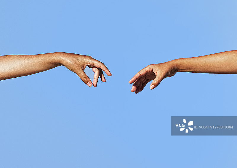 两位女士的手臂伸向彼此图片素材