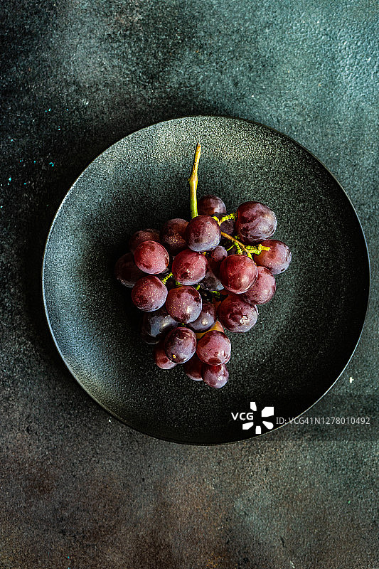 陶瓷盘中一串红葡萄的俯视照片图片素材