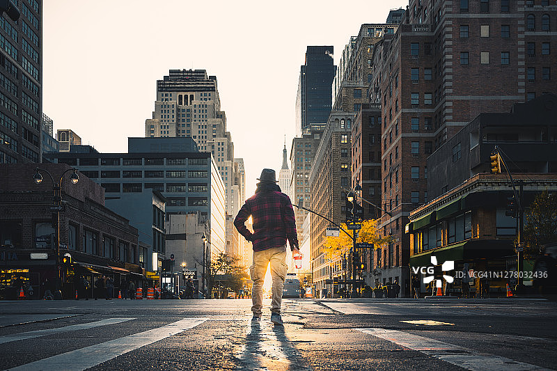 手拿咖啡纸杯站在纽约市道路上的男人图片素材