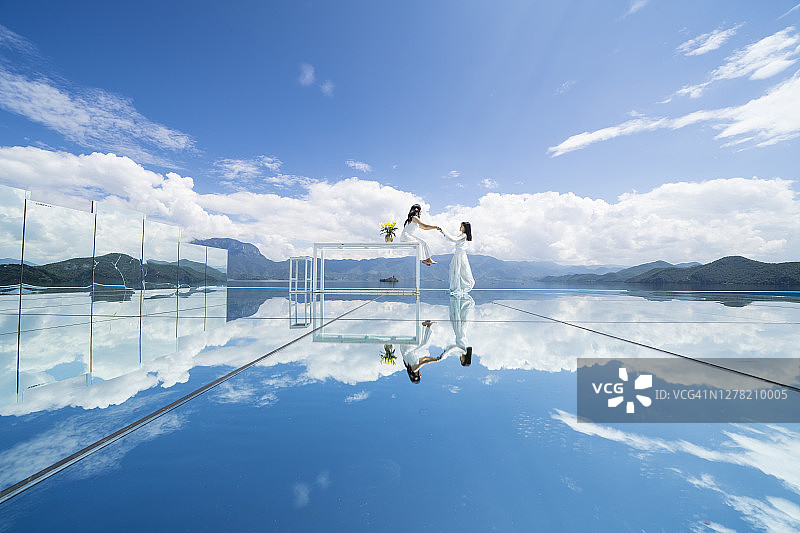 快乐的中国母女手牵手在大玻璃镜前图片素材