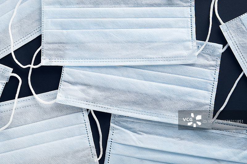 黑色背景上的白色医用一次性防护口罩图片素材