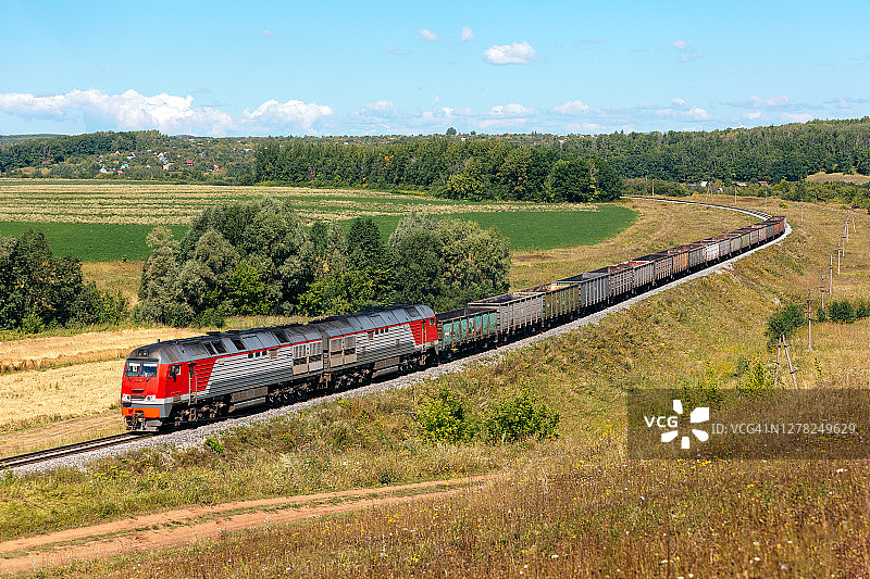 在美丽的乡村，现代柴油发动机牵引着一列短货运列车图片素材