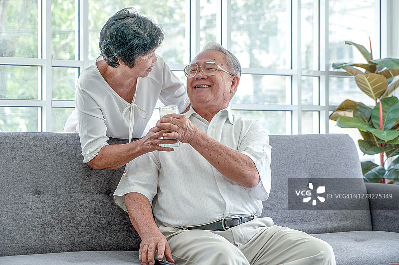快乐的夫妇在沙发上放松，享受家庭周末图片素材