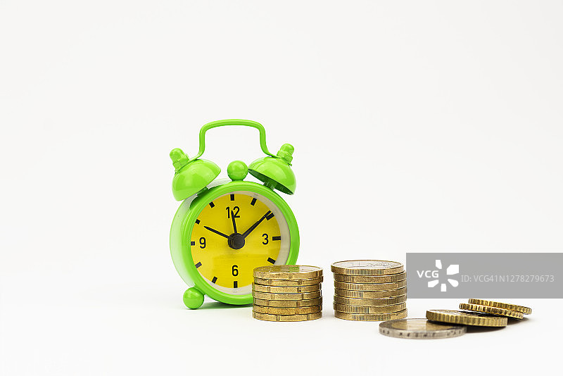 白色背景上的硬币和闹钟图片素材
