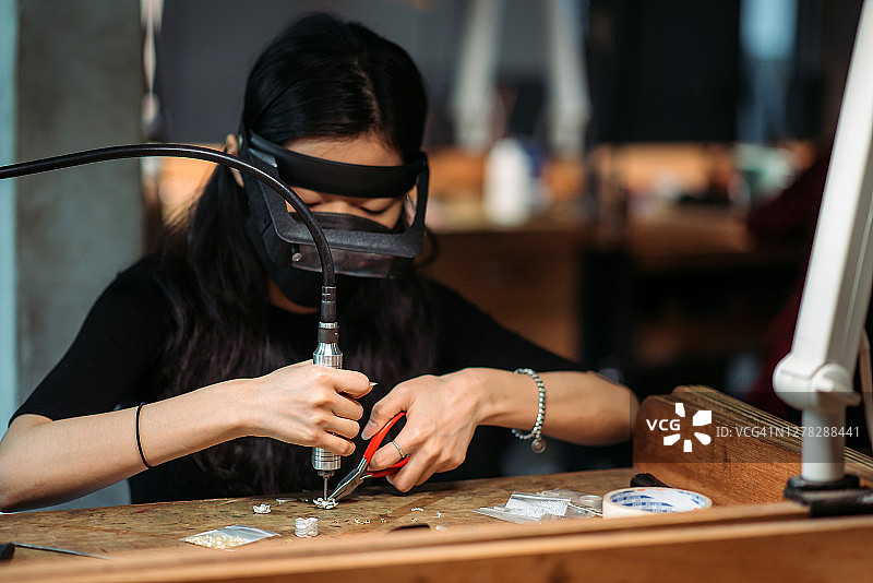 在大学工作台上制作珠宝的亚洲韩国女学生图片素材