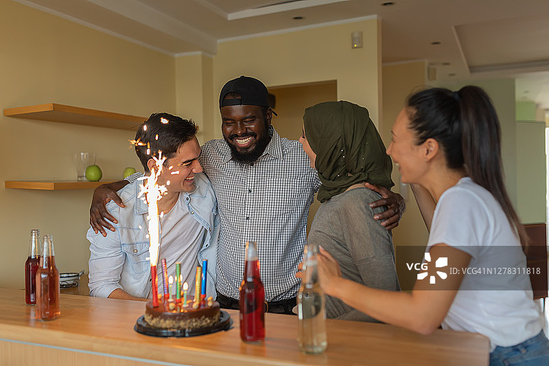 在客厅庆祝生日的多元种族朋友图片素材