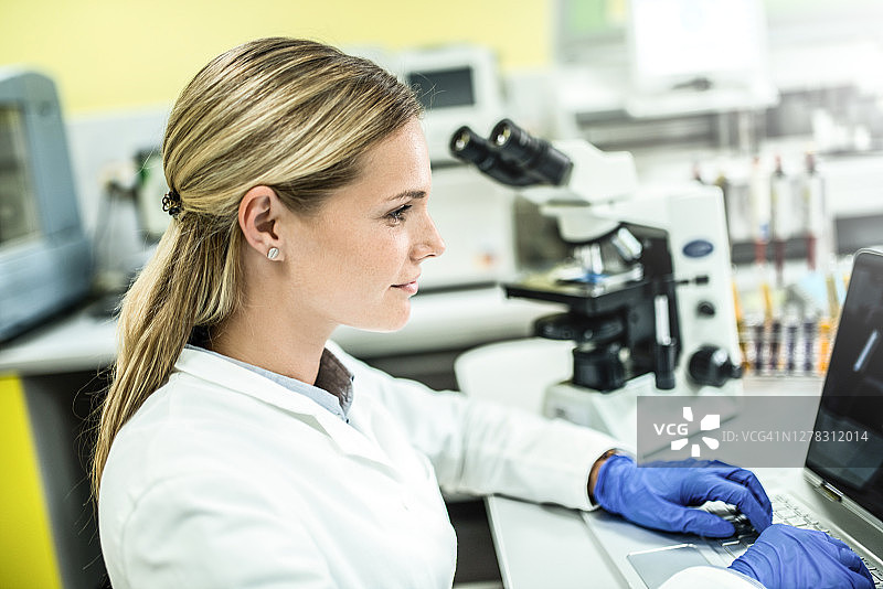 在实验室使用电脑的年轻女科学家图片素材