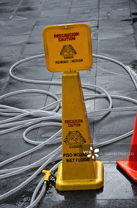 人行道上的多语种“小心地滑”塑料警示牌图片素材