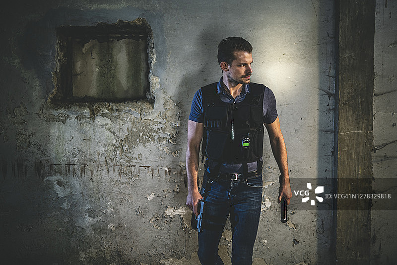 警察夜晚站在破败的城市环境中图片素材