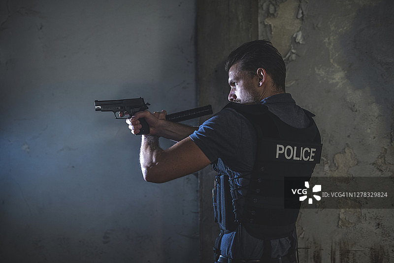 年轻男警官瞄准手枪的侧视图图片素材