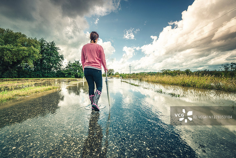 女人在被洪水淹没的道路上图片素材
