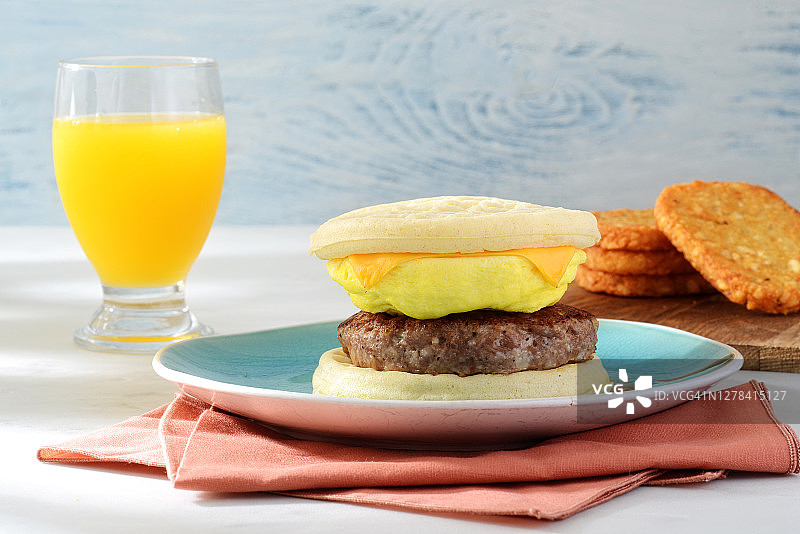 香肠鸡蛋奶酪华夫饼三明治与橙汁图片素材
