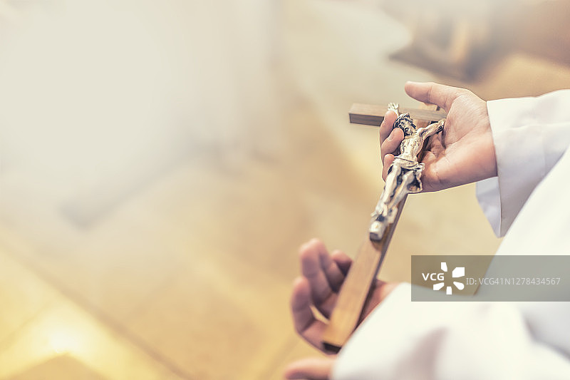 神职人员在弥撒中手持耶稣受难像小十字架图片素材