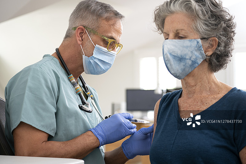 医生为老年妇女接种疫苗图片素材