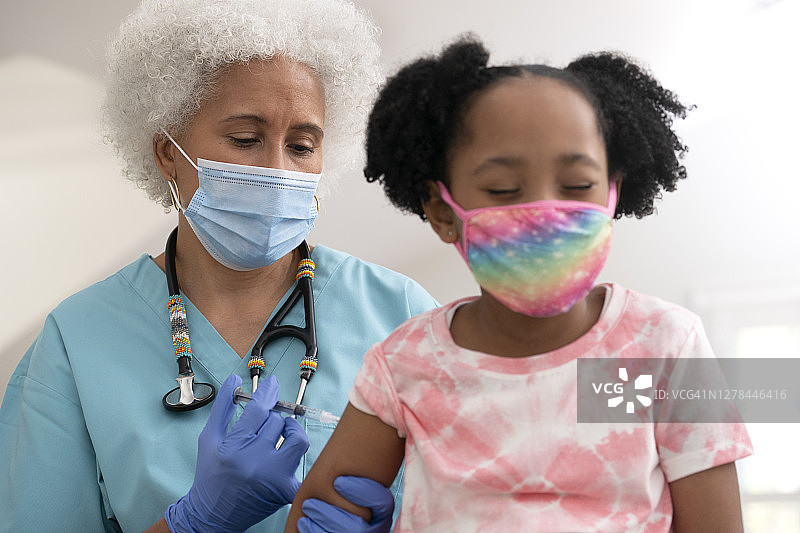 医护人员为年轻女孩接种疫苗图片素材