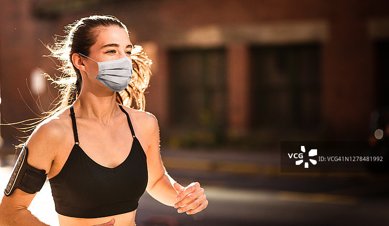 封锁期间戴口罩的健身女人图片素材