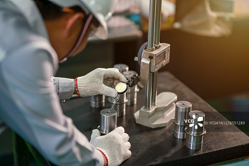 生产工人使用千分尺检测金属产品图片素材