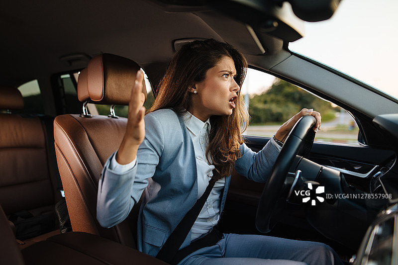 沮丧的女商人开车时大喊大叫图片素材