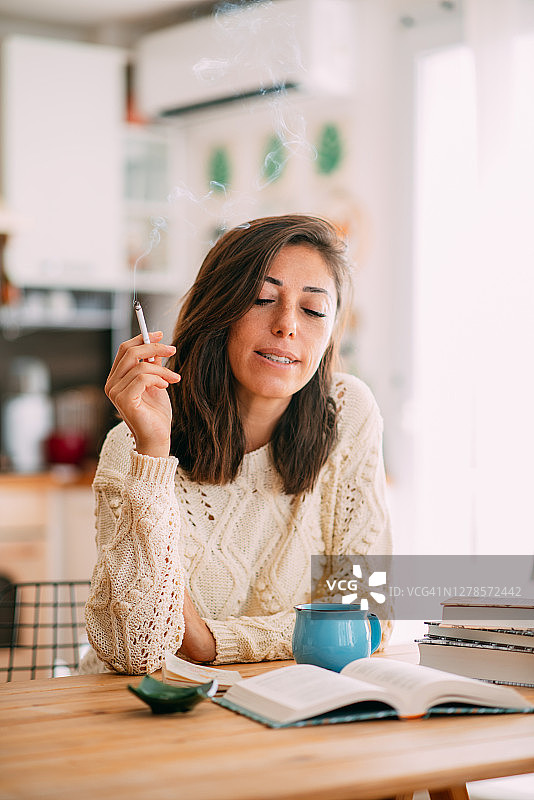 在家边看书边喝咖啡抽烟的女人图片素材