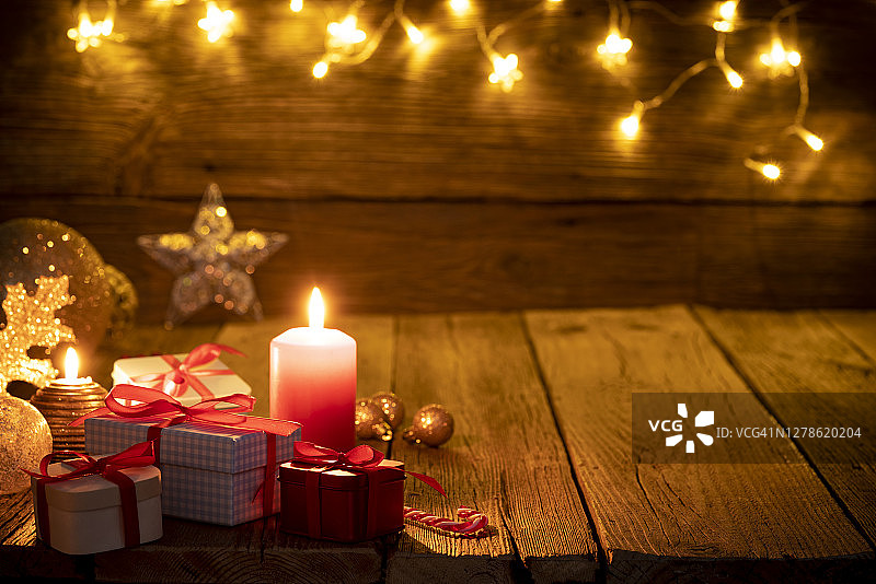 圣诞节背景：红色蜡烛、礼物和乡村木质装饰图片素材