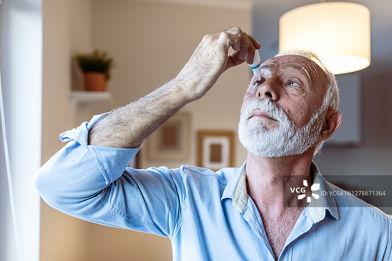 老年男人滴眼药水，解决视力问题图片素材
