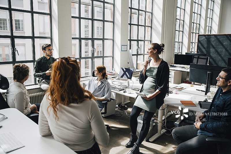 办公室同事靠窗讨论的高角度视图图片素材