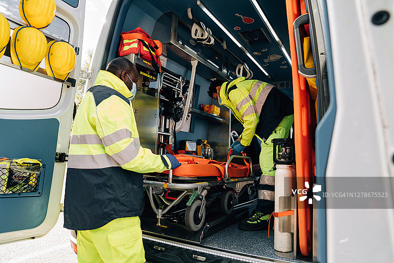 两名护理人员在救护车旁抬着担架图片素材