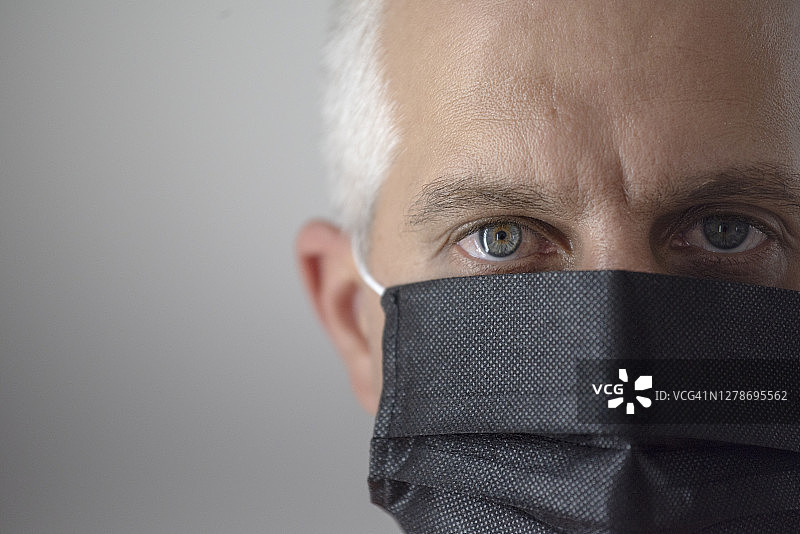 戴着黑色防护面罩的白发浅色眼睛男子图片素材