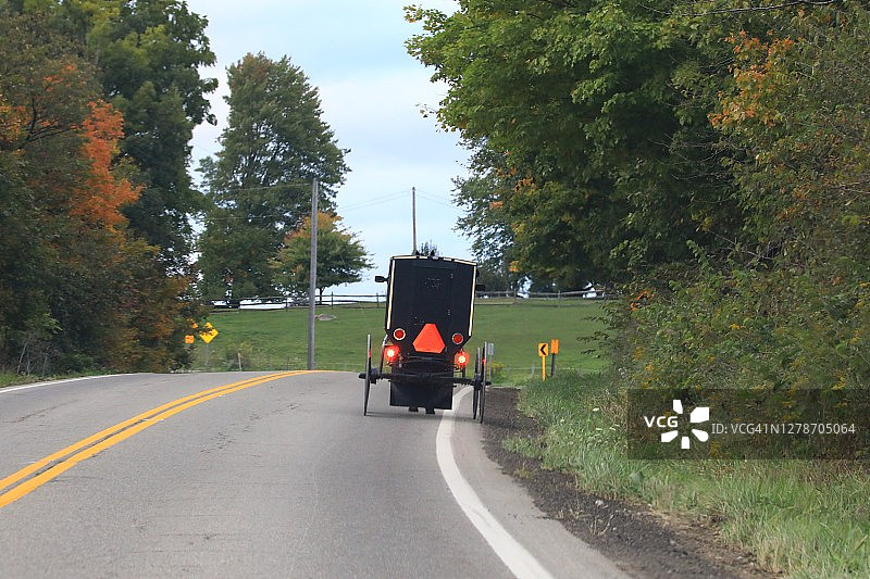 行驶着阿米什马车的乡间小路图片素材
