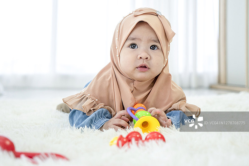在床上爬行和翻滚的可爱女婴图片素材