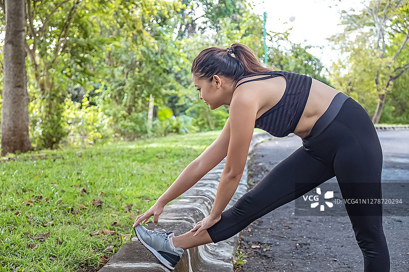 跑步后伸展腿筋的中国女人图片素材