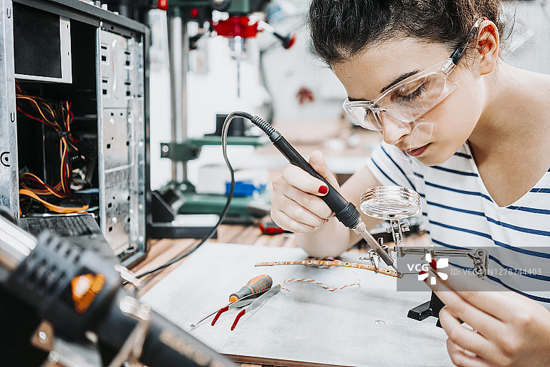 年轻女人修理和组装电脑图片素材