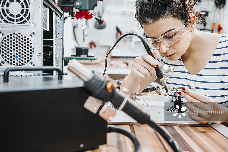 年轻女人修理和组装电脑图片素材