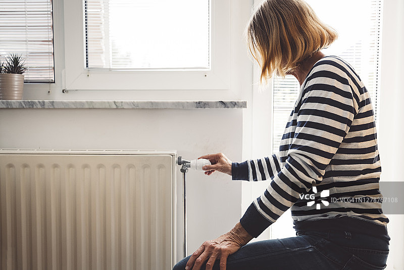 女人手持暖气阀图片素材
