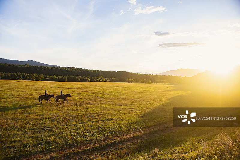 美国犹他州塞勒姆：姐妹（14-15岁）在日落时骑马图片素材