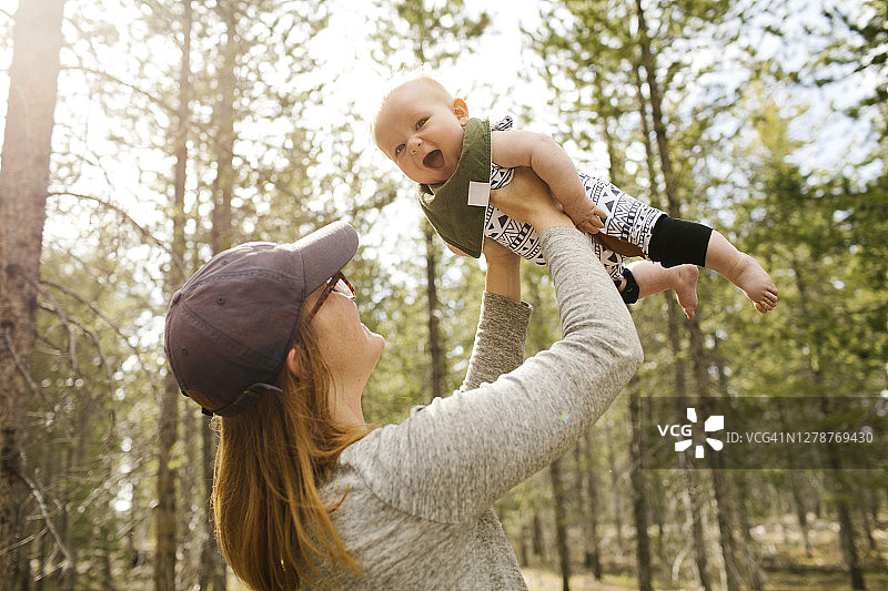 在森林里抱着婴儿儿子的女人图片素材