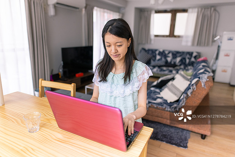 穿睡衣的年轻女人在家工作图片素材