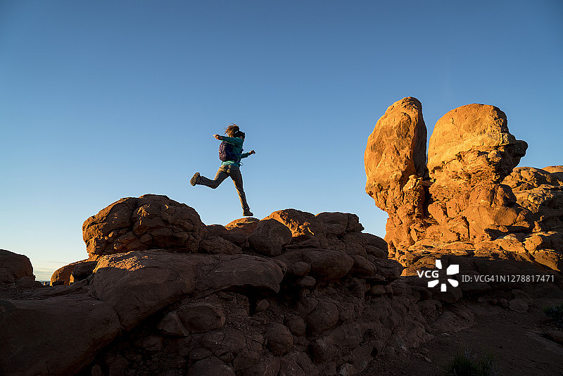 女人在拱门国家公园风景优美的步道上徒步旅行图片素材